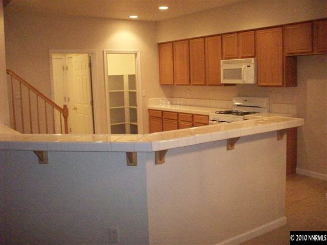 9668 Rolling Rock Way Reno, NV 89521 - Photo 6 of 9 a kitchen with stainless steel appliances a refrigerator and a stove