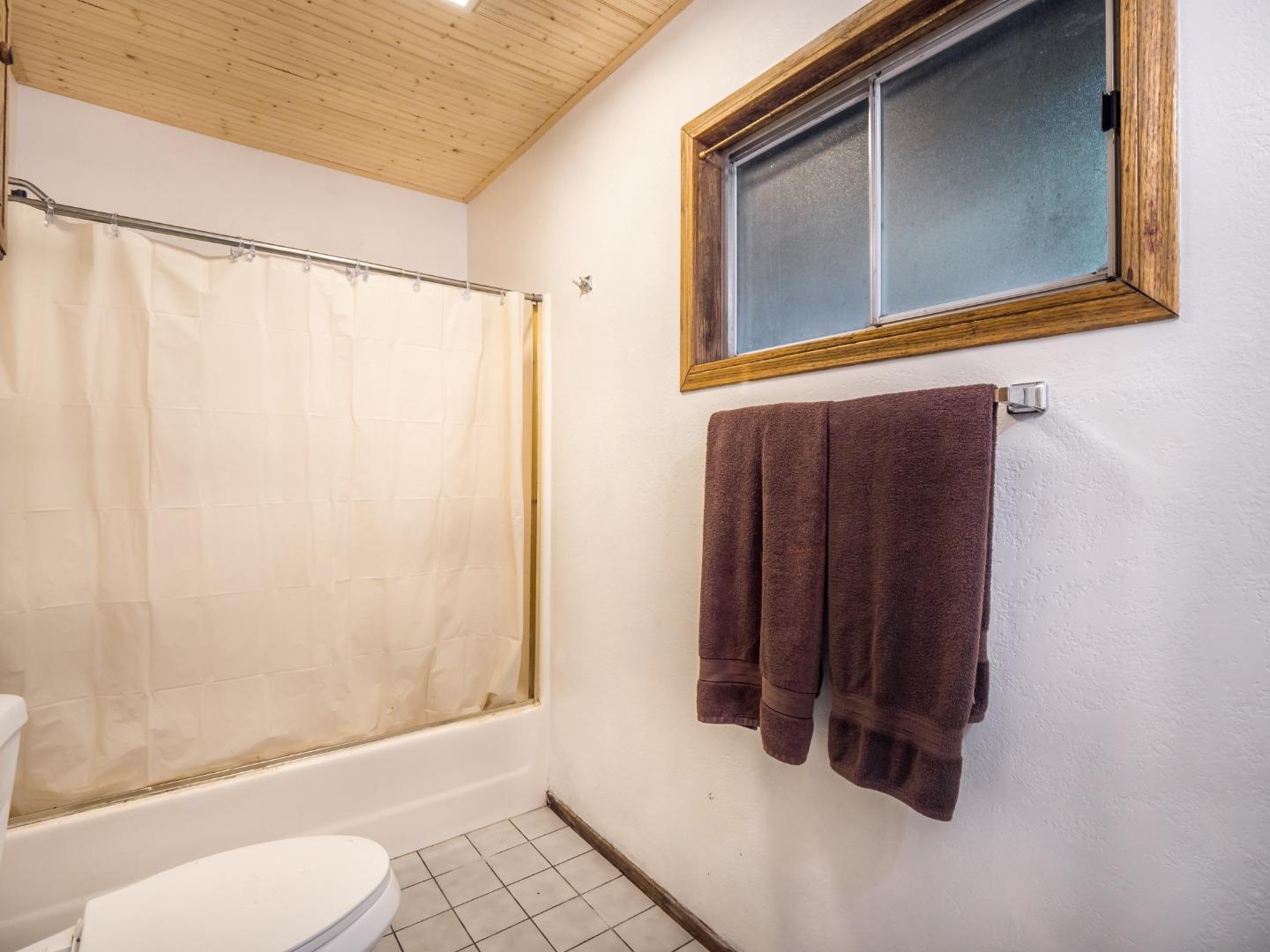 10970 Riverside Road Brookdale, CA 95005 - Photo 22 of 27 a bathroom with a shower curtain and a window