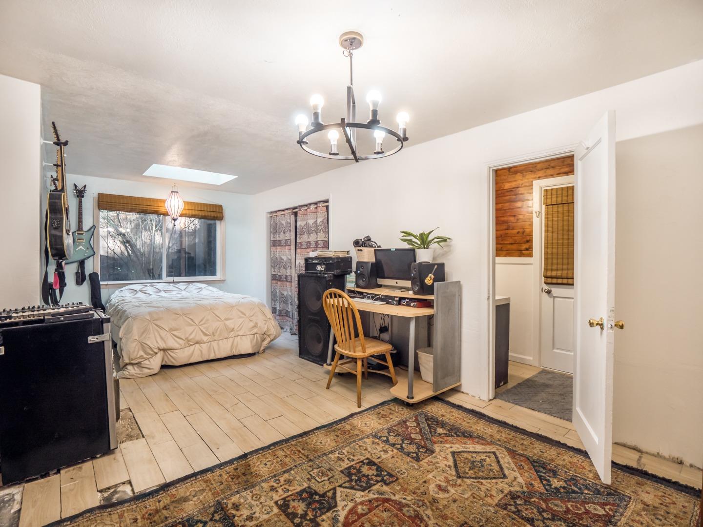 10970 Riverside Road Brookdale, CA 95005 - Photo 23 of 27 a bedroom with a bed and a chandelier