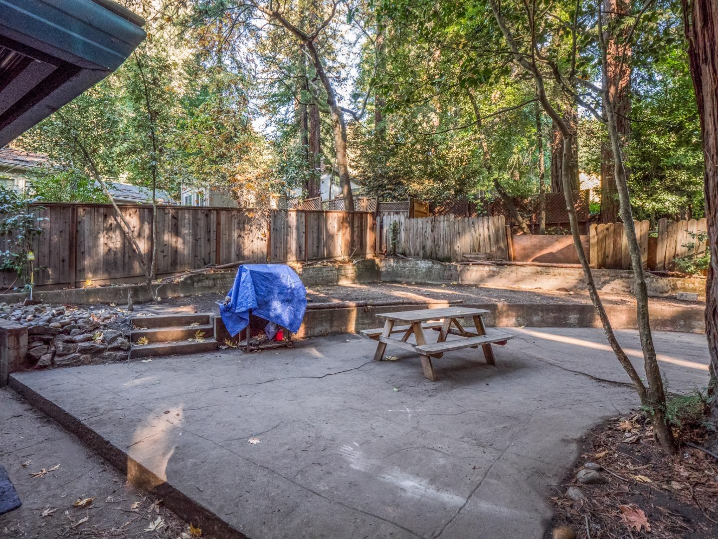10970 Riverside Road Brookdale, CA 95005 - Photo 6 of 27 a view of a patio with table and chairs and a large tree
