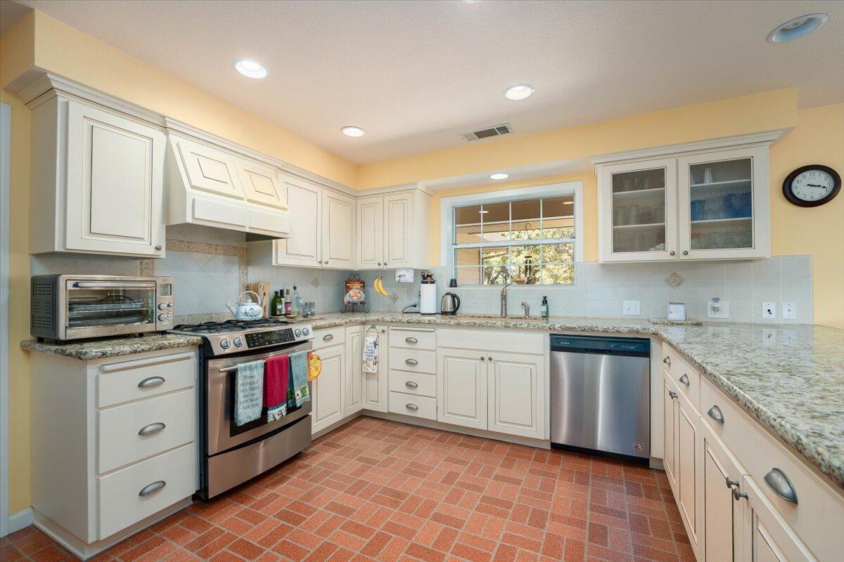 19035 Bonita Road Red Bluff, CA 96080 - Photo 12 of 55 a kitchen with granite countertop cabinets stainless steel appliances a sink and a window