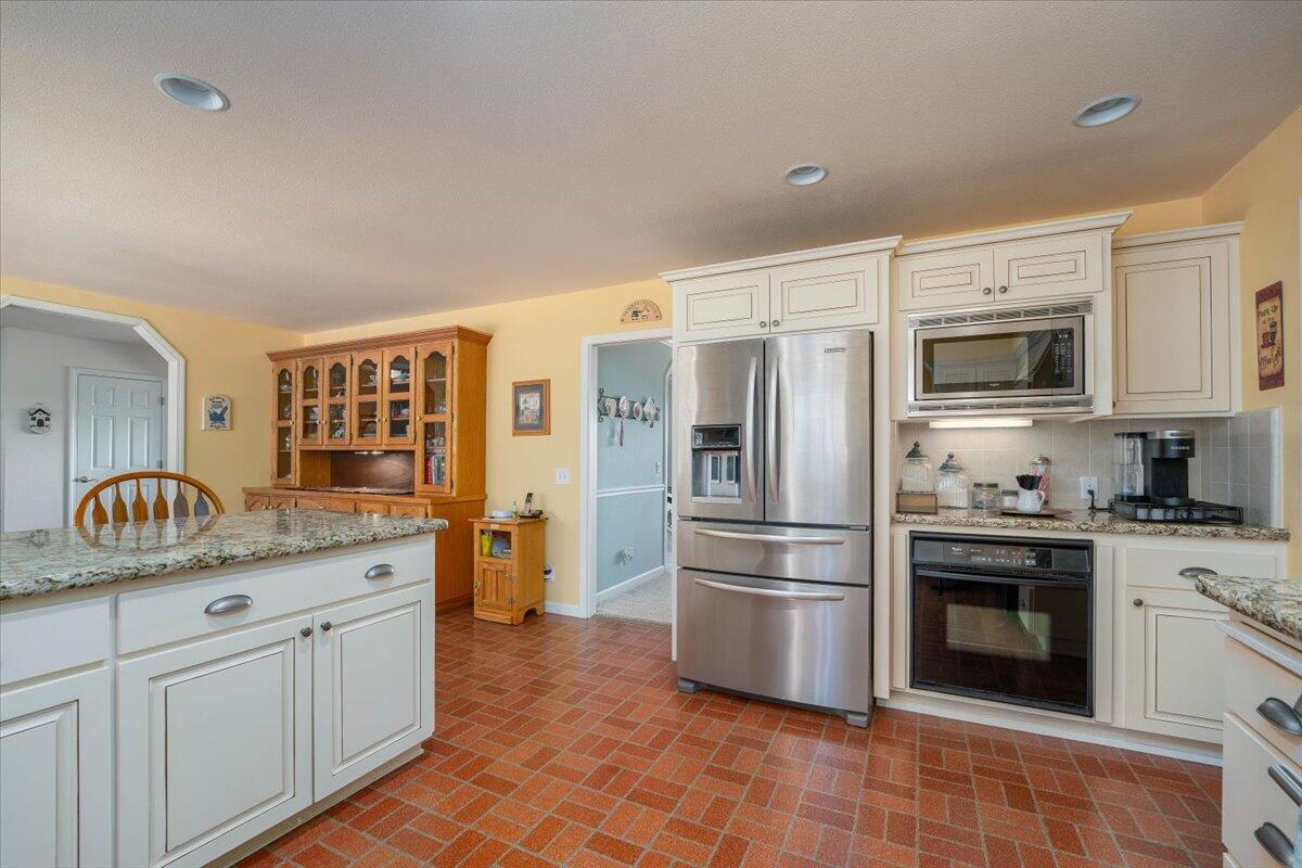 19035 Bonita Road Red Bluff, CA 96080 - Photo 13 of 55 a kitchen with granite countertop a sink stainless steel appliances and white cabinets