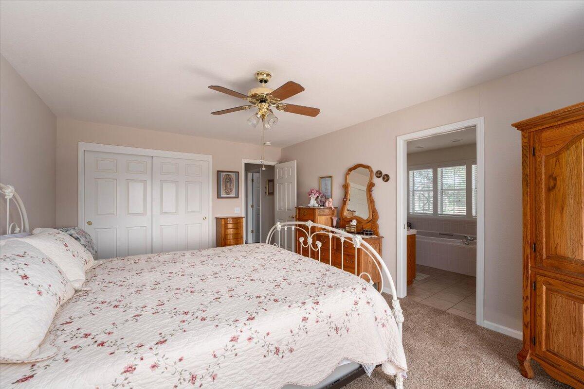 19035 Bonita Road Red Bluff, CA 96080 - Photo 24 of 55 a bedroom with a large bed and a chandelier