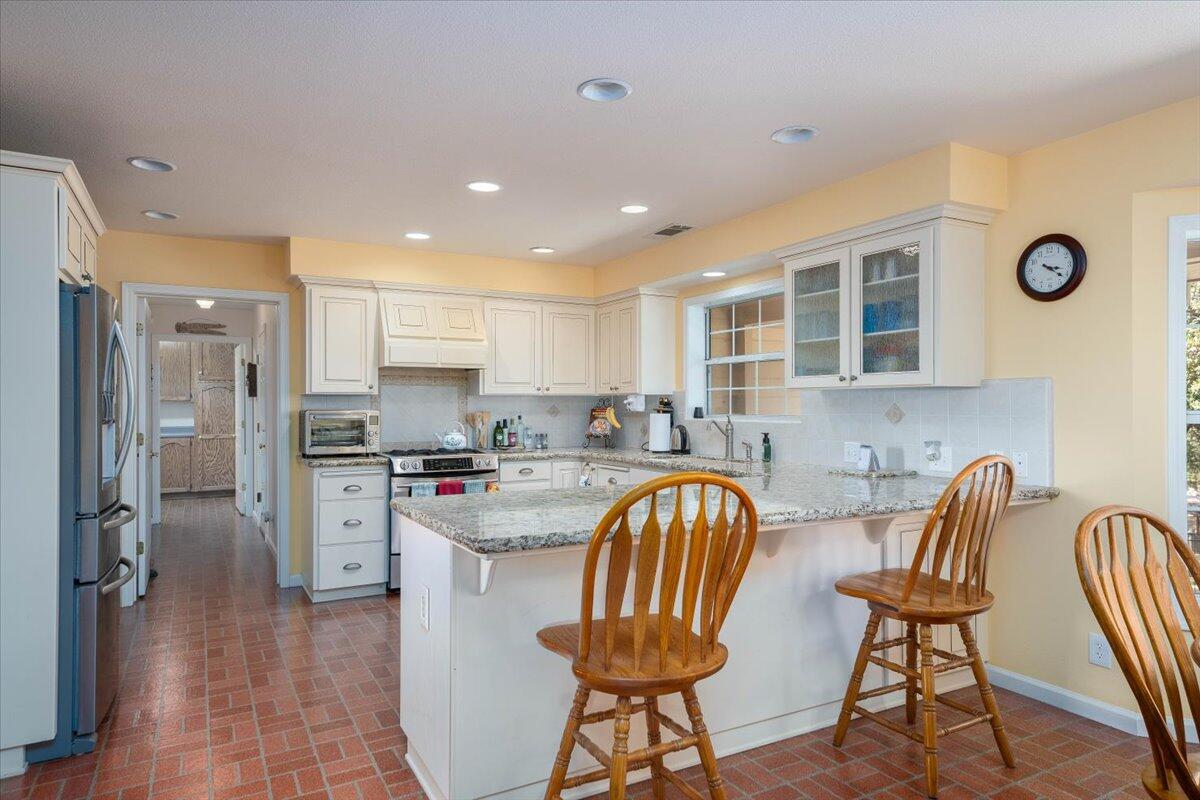 19035 Bonita Road Red Bluff, CA 96080 - Photo 10 of 55 a kitchen with stainless steel appliances granite countertop a dining table chairs refrigerator sink and cabinets