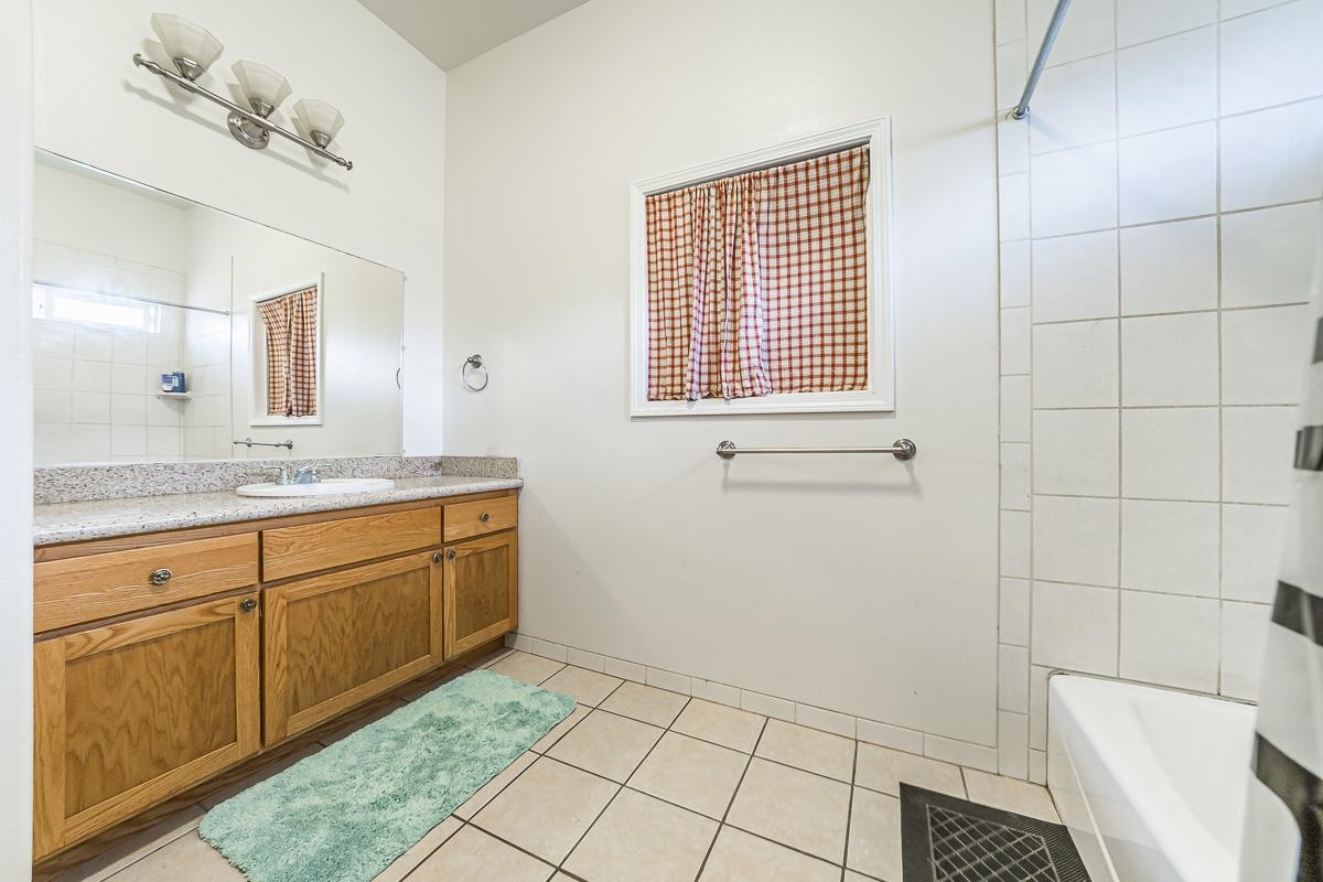2640 Puuomalei Road Haiku, HI 96708 - Photo 27 of 30 a spacious bathroom with a granite countertop sink a toilet and mirror