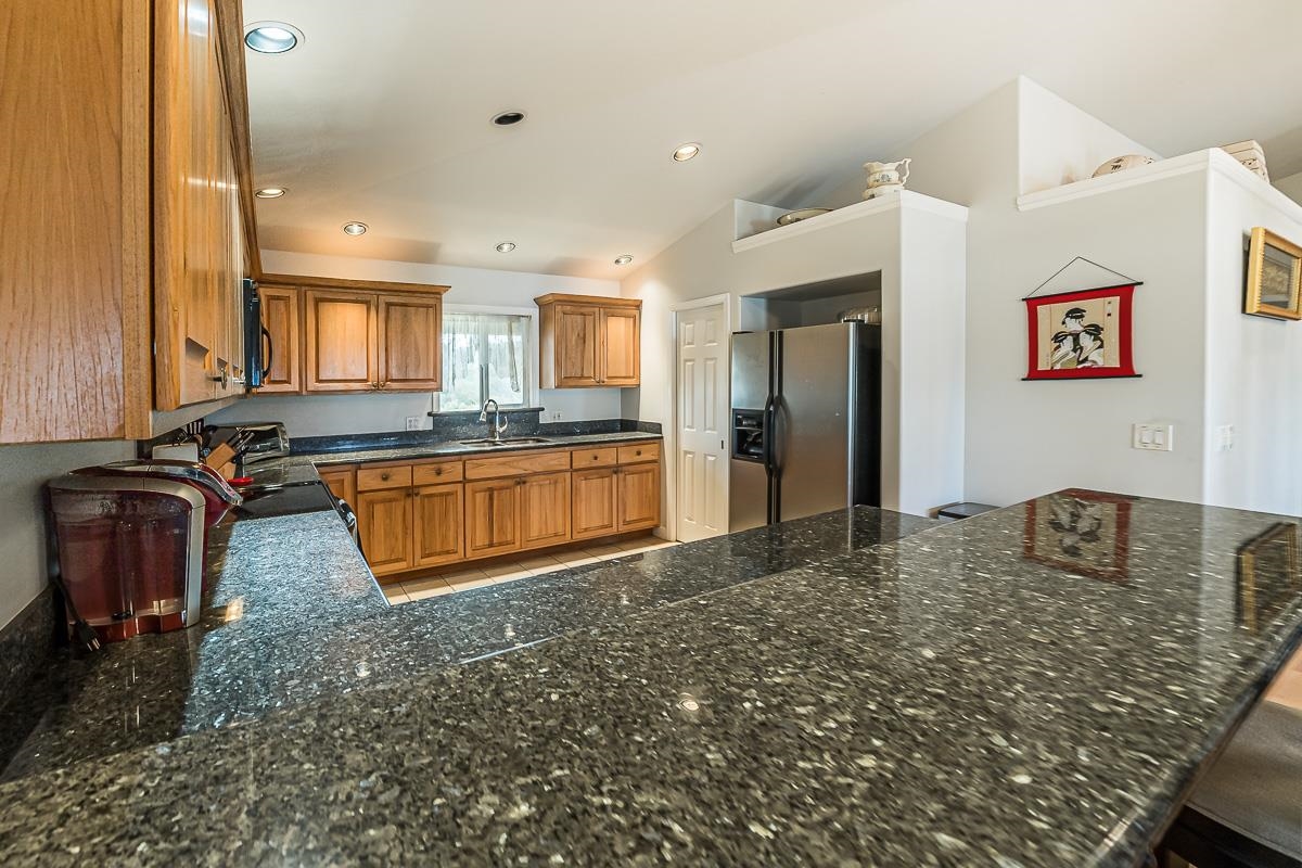 2640 Puuomalei Road Haiku, HI 96708 - Photo 4 of 30 a kitchen with stainless steel appliances granite countertop a sink stove and refrigerator