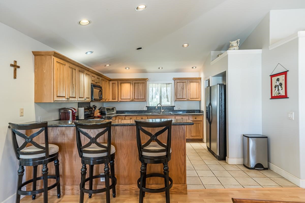 2640 Puuomalei Road Haiku, HI 96708 - Photo 5 of 30 a kitchen with a table chairs refrigerator and cabinets