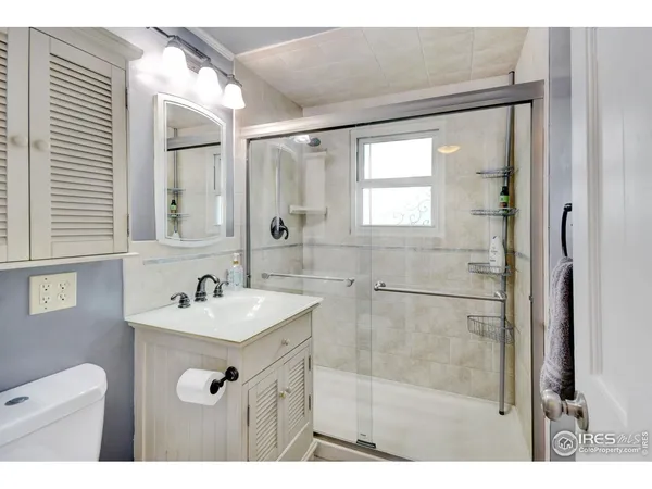 a bathroom with a sink mirror and a shower