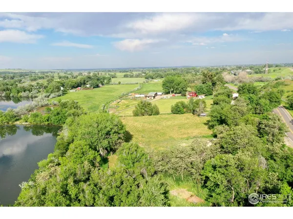 an aerial view of residential houses with outdoor space and lake view