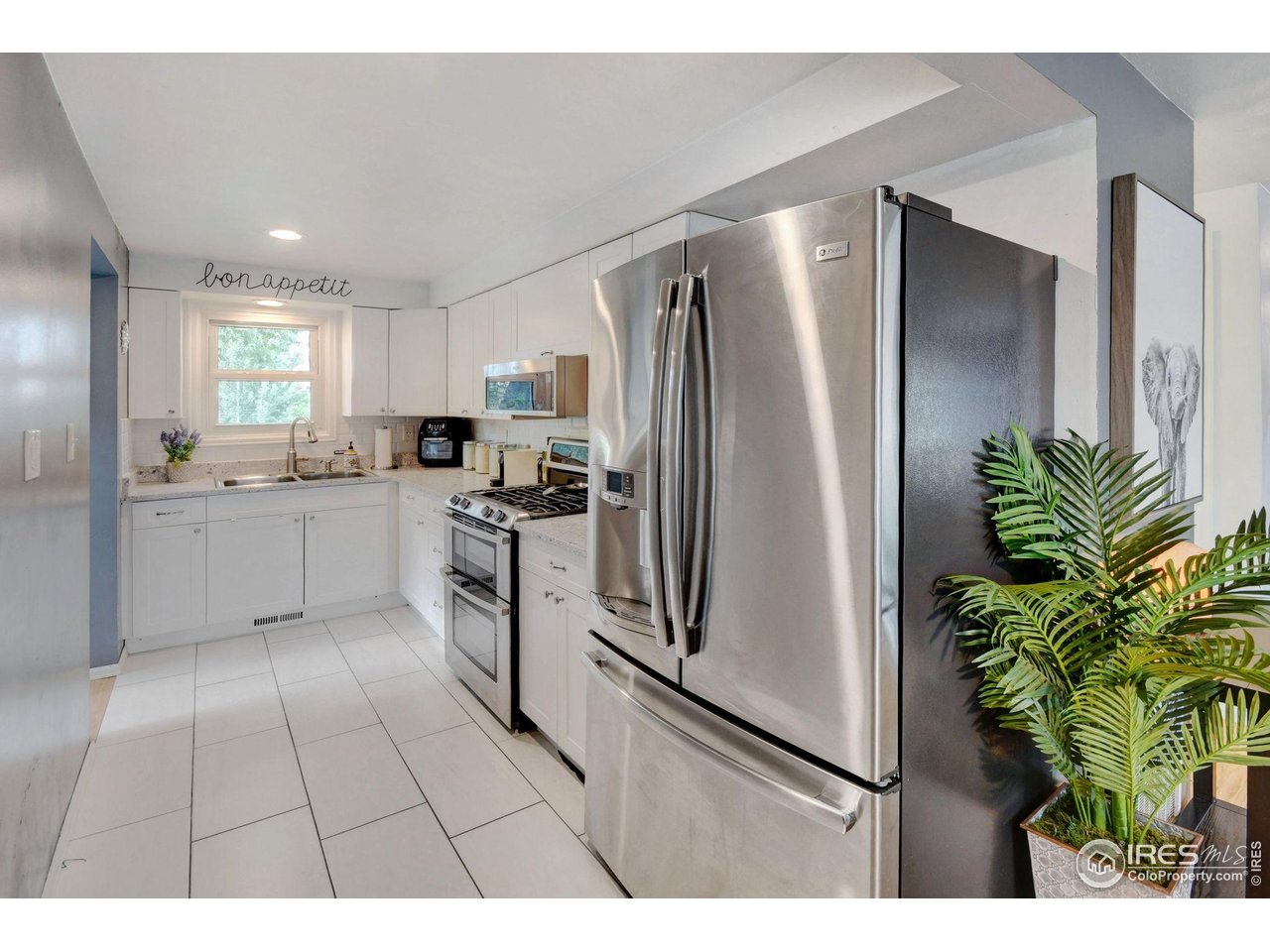 6903 Valmont Road Boulder, CO 80301 - Photo 7 of 44 a kitchen with stainless steel appliances a refrigerator a sink a counter space and a window