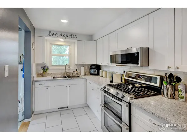 a kitchen with stainless steel appliances kitchen island granite countertop a stove a sink and a microwave