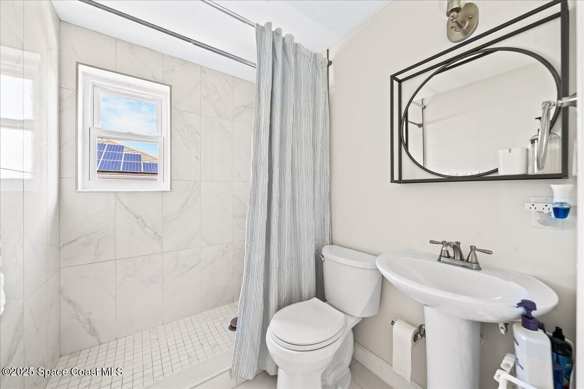 466 Lanternback Island Drive Satellite Beach, FL 32937 - Photo 52 of 117 a bathroom with a toilet a sink and a mirror