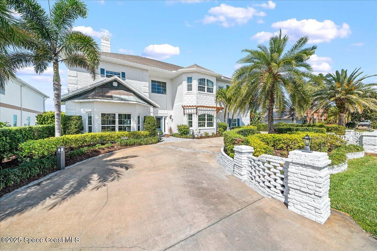 466 Lanternback Island Drive Satellite Beach, FL 32937 - Photo 92 of 117 a front view of a house with a garden and patio