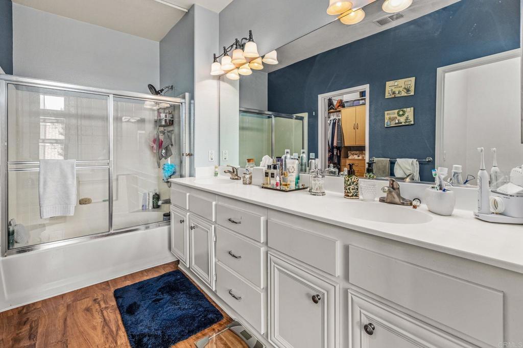 625 Sumner Way, Unit 2 Oceanside, CA 92058 - Photo 21 of 31 a spacious bathroom with a double vanity sink a mirror a bathtub and next to a window