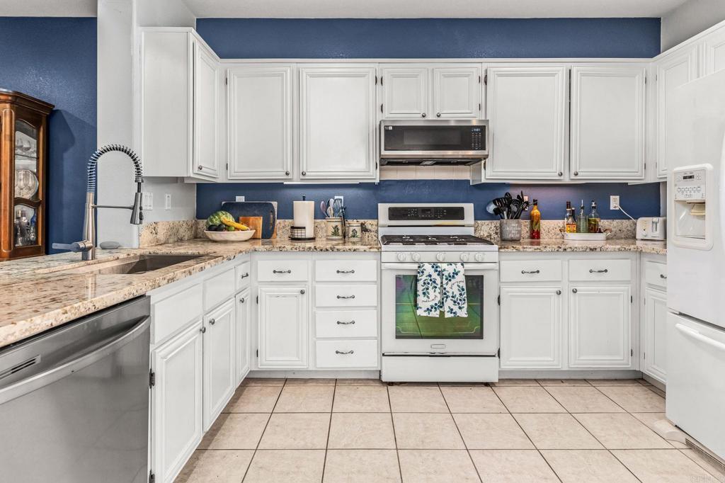 625 Sumner Way, Unit 2 Oceanside, CA 92058 - Photo 9 of 31 a kitchen with stainless steel appliances granite countertop a sink a stove a chimney a refrigerator and cabinets