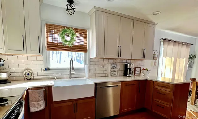 a kitchen with granite countertop a sink cabinets stainless steel appliances and a window