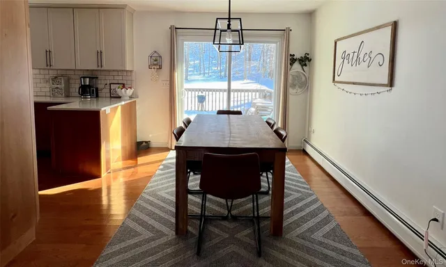 a dining room with stainless steel appliances wooden floor dining table and chairs