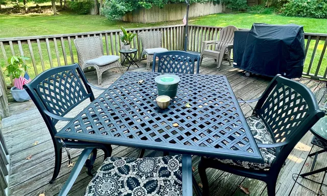 a view of balcony with wooden floor outdoor seating and yard in back