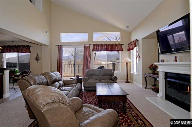 14105 Princequillo Court Reno, NV 89521 - Photo 4 of 9 a living room with furniture a flat screen tv and a fireplace