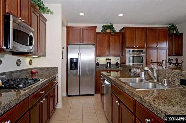 14105 Princequillo Court Reno, NV 89521 - Photo 6 of 9 a kitchen with granite countertop a sink dishwasher stove and refrigerator with wooden floor