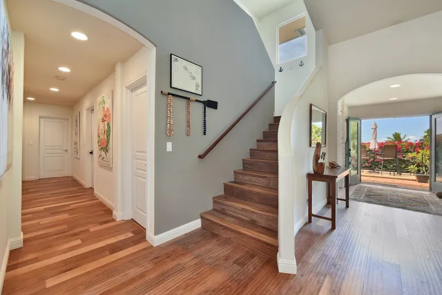 a view of a hallway with wooden floor and stairs