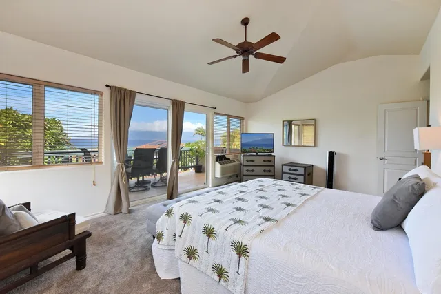 a bedroom with a bed a large window and furniture