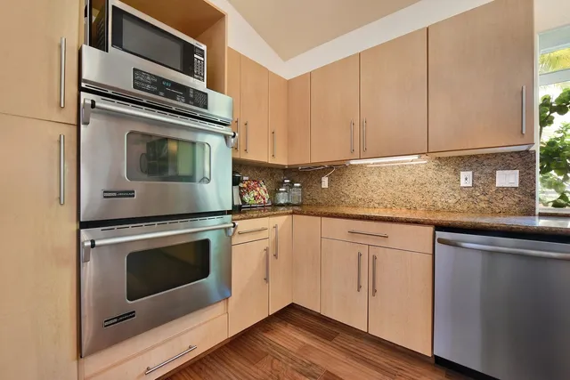 a kitchen with granite countertop cabinets stainless steel appliances and wooden cabinets