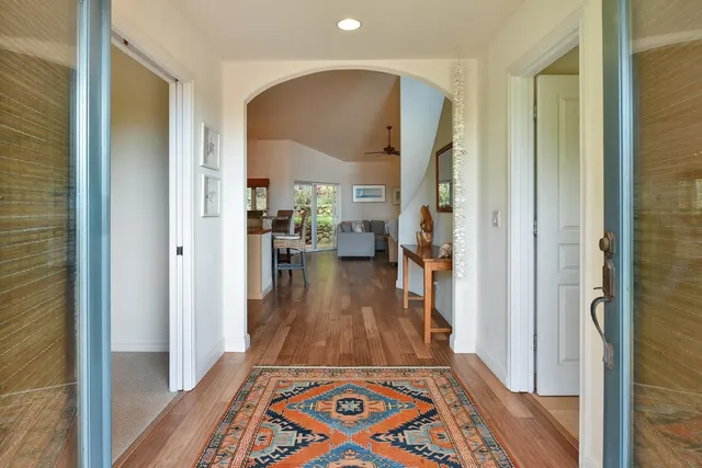 a view of a hallway with wooden floor windows and a livingroom
