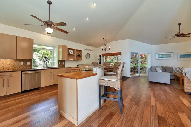 a kitchen with stainless steel appliances granite countertop wooden floors a stove and a sink