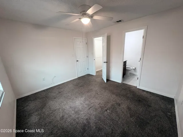 a view of empty room with a ceiling fan and window