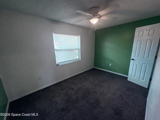 a view of a livingroom with an empty space and a ceiling fan