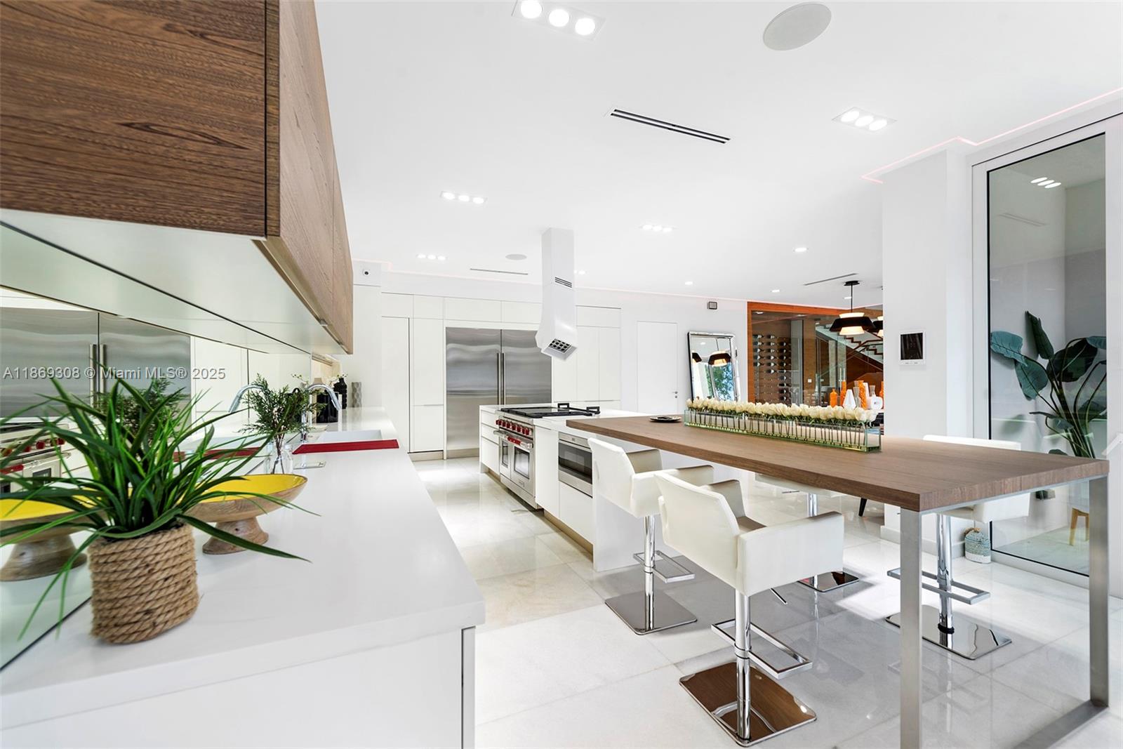 7450 Southwest 102nd Street Pinecrest, FL 33156 - Photo 13 of 51 a kitchen with stainless steel appliances kitchen island granite countertop a table chairs in it and wooden floor
