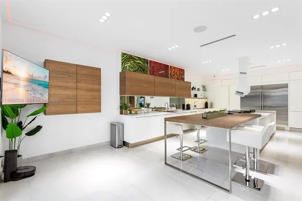 a kitchen with stainless steel appliances kitchen island granite countertop a stove a sink and a white cabinets