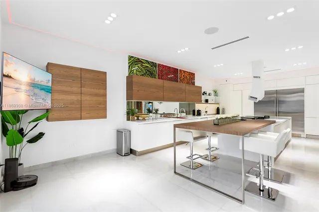 a kitchen with stainless steel appliances kitchen island granite countertop a stove a sink and a white cabinets