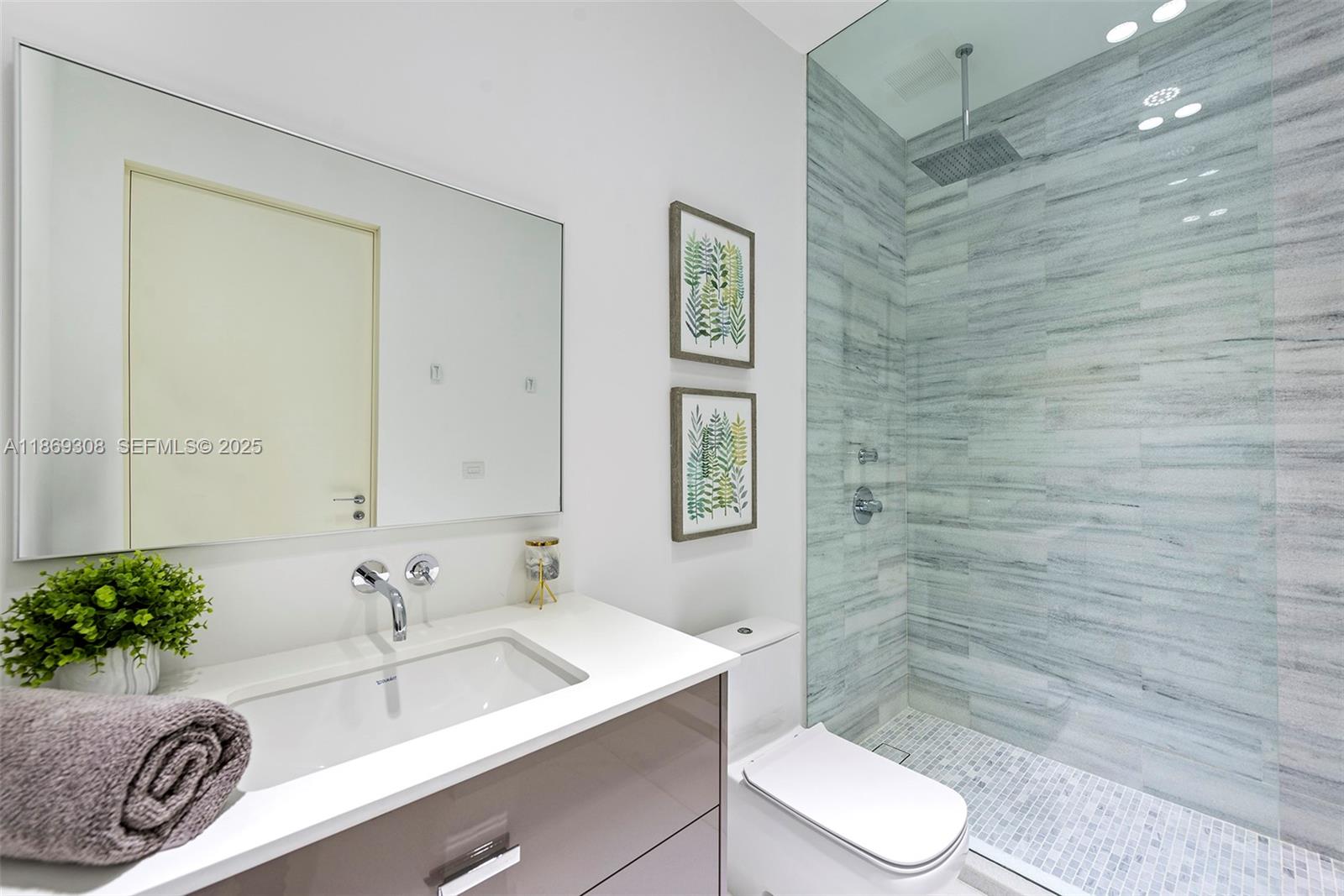 7450 Southwest 102nd Street Pinecrest, FL 33156 - Photo 39 of 51 a bathroom with a granite countertop sink mirror vanity and toilet