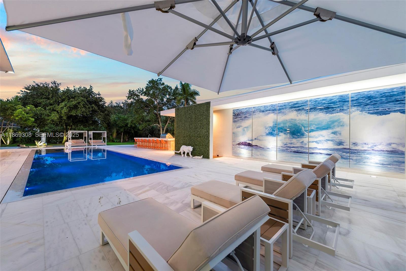 7450 Southwest 102nd Street Pinecrest, FL 33156 - Photo 49 of 51 a patio with a table and chairs under an umbrella