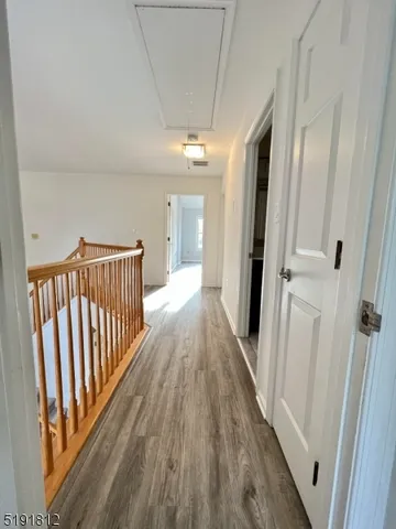 a view of a hallway with wooden floor and staircase