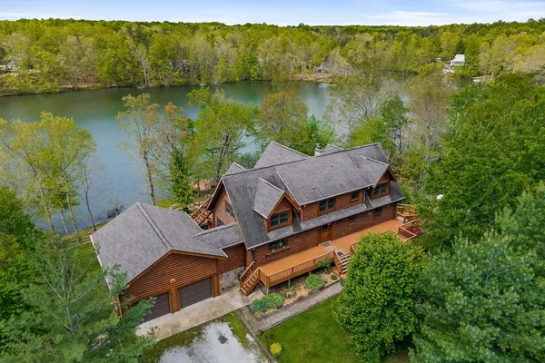 an aerial view of a house with garden space and a lake view