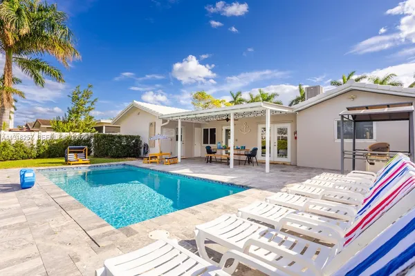 a view of a house with swimming pool and sitting area