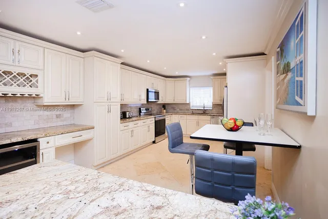 a kitchen with granite countertop white cabinets and white appliances