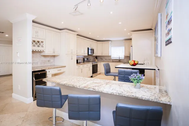 a kitchen with stainless steel appliances white cabinets and sink