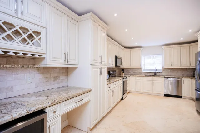 a kitchen with stainless steel appliances kitchen island granite countertop a refrigerator and a stove top oven