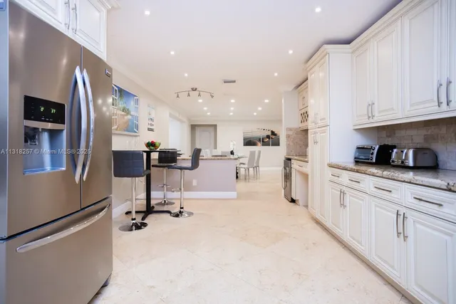 a dining room with furniture a table and kitchen view