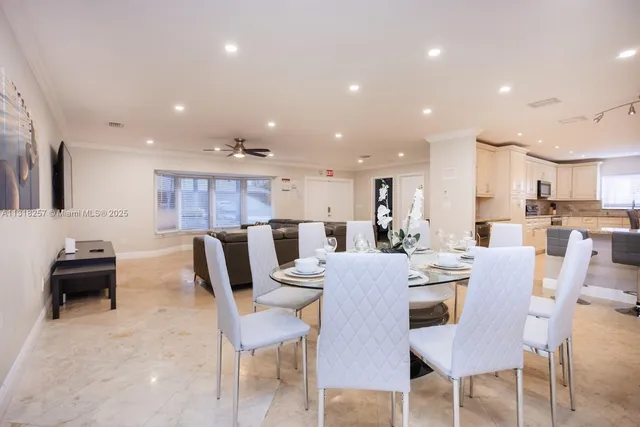 a kitchen with stainless steel appliances a dining table and chairs