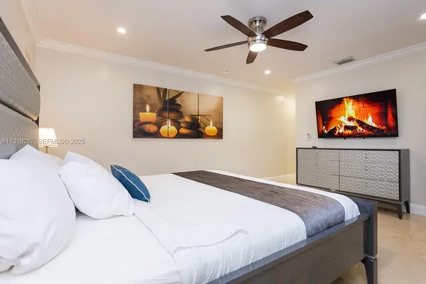 a spacious bedroom with a bed and a chandelier
