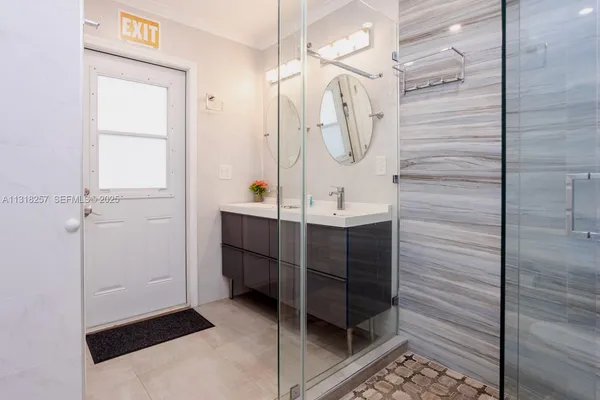 a bathroom with a sink a toilet and shower