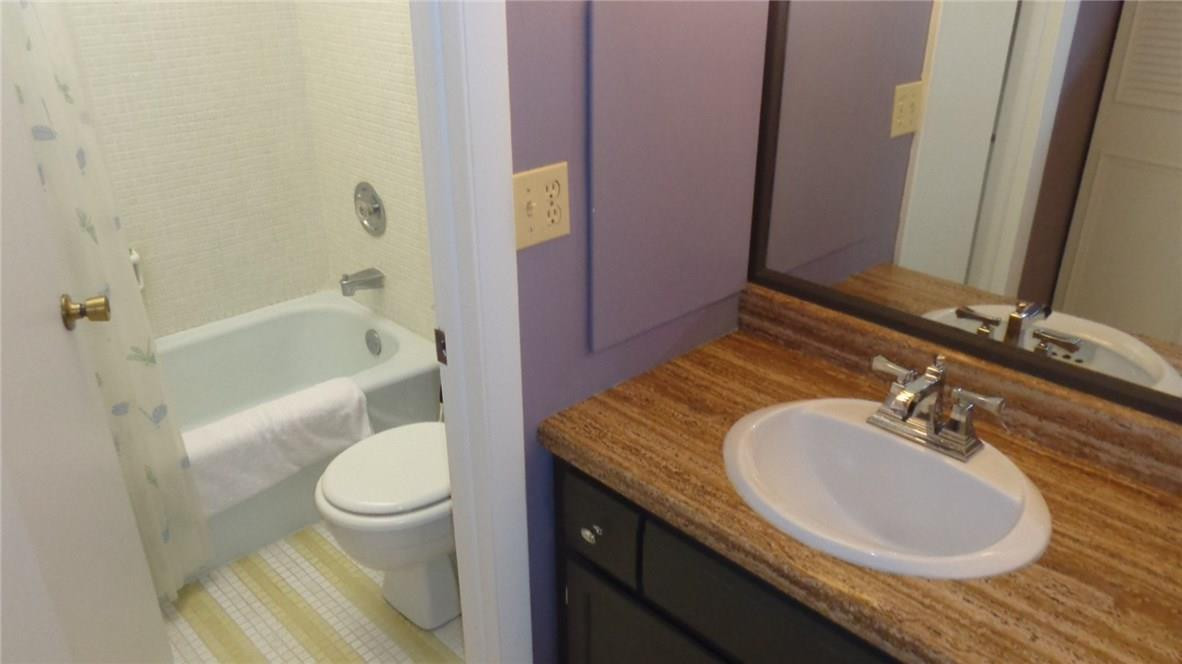 3670 Inverrary Drive, Unit 2C Lauderhill, FL 33319 - Photo 9 of 21 a bathroom with a granite countertop sink and a mirror