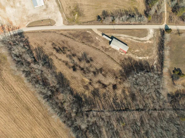 an aerial view of a house with a garden and lake view