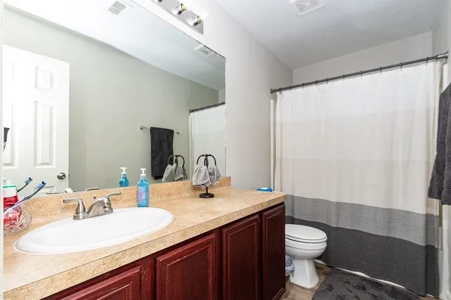 a bathroom with a granite countertop sink toilet and shower