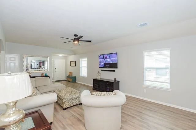 a living room with furniture a fireplace and a flat screen tv